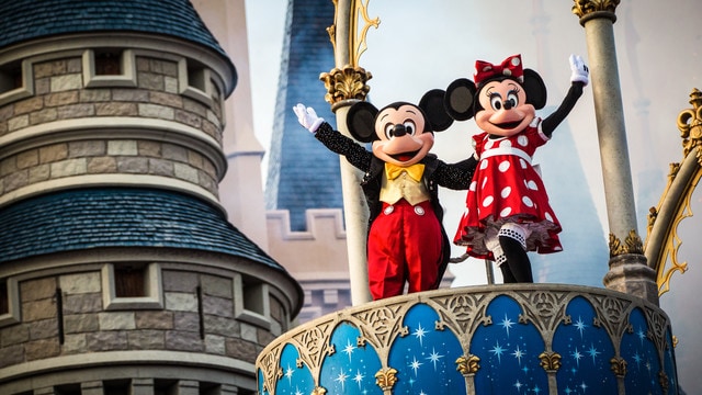 Mickey and Minnie wave from a perch at Cinderella Castle